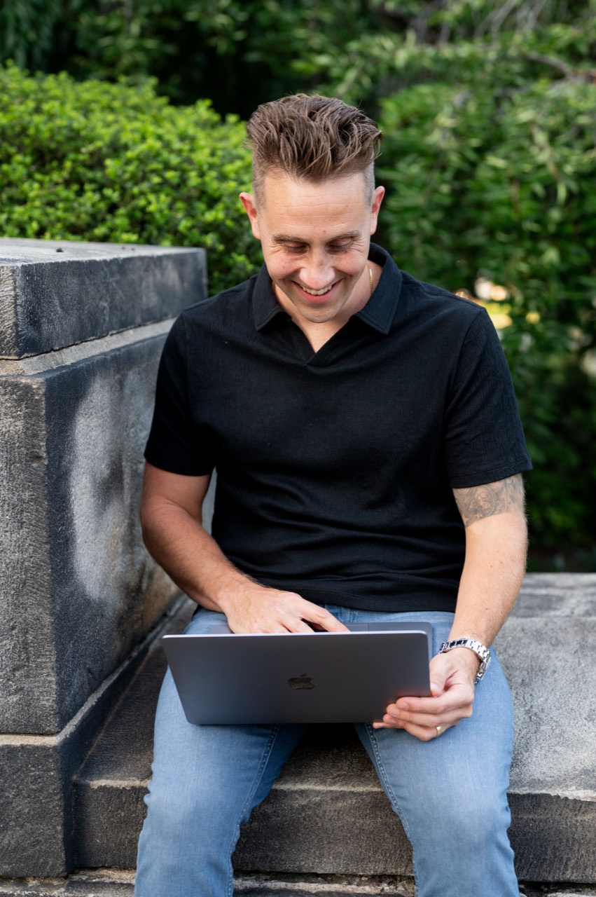 Chase Freezman working on his laptop outdoors